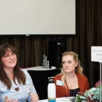 A group of attendees discuss climate change at their round table.